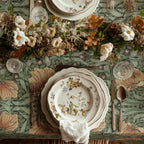 William Morris Pimpernel tablecloth in Sage and Amber draped over a table edge