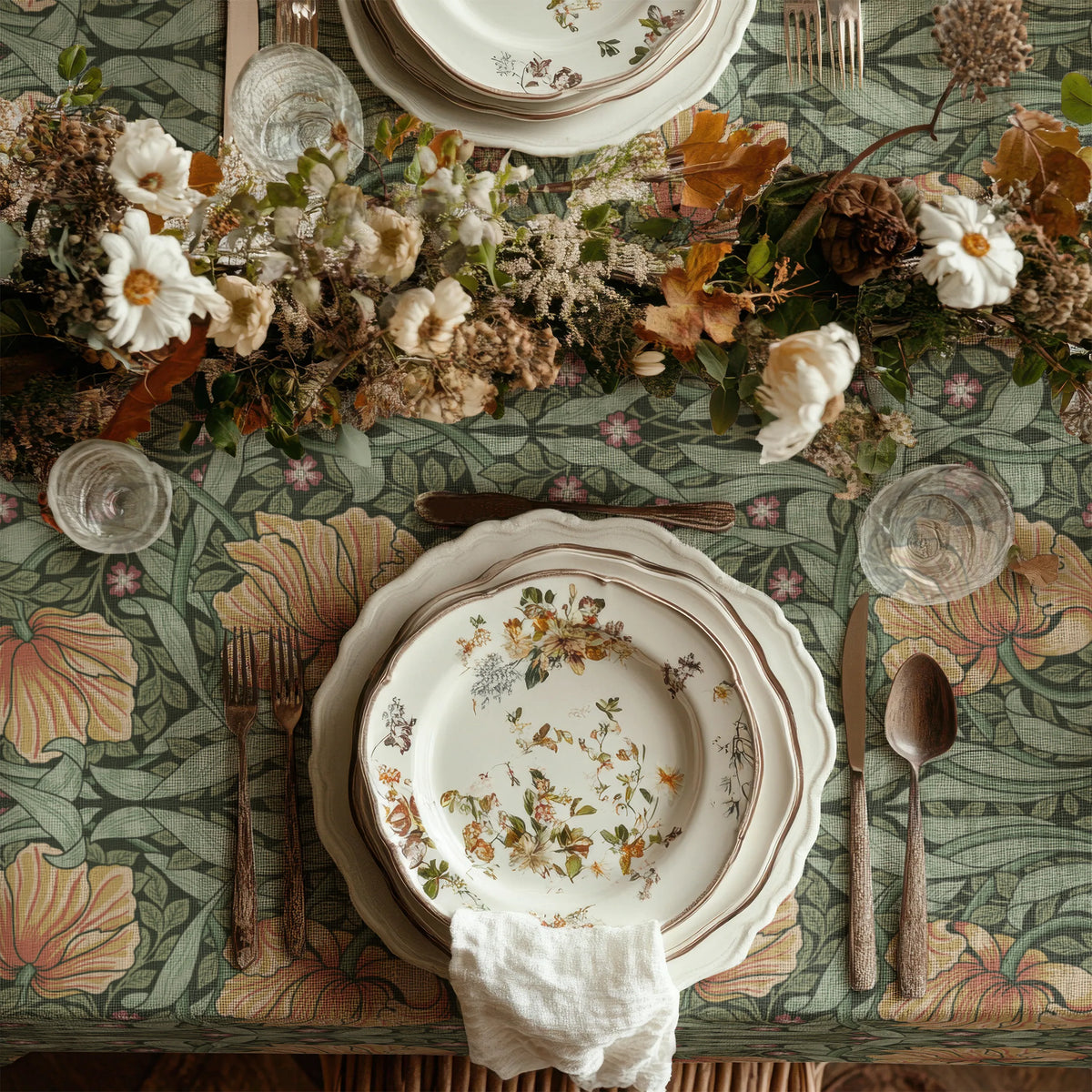 William Morris Pimpernel tablecloth in Sage and Amber draped over a table edge