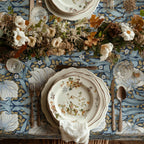 William Morris Pimpernel tablecloth in Blue and Gold draped over a table edge
