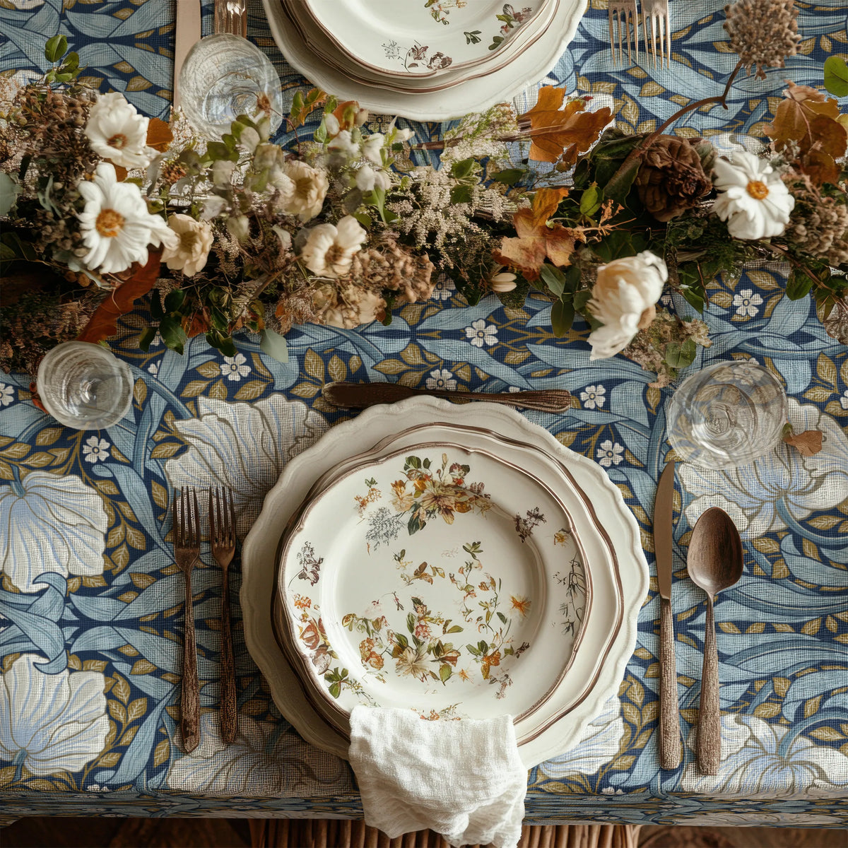 William Morris Pimpernel tablecloth in Blue and Gold draped over a table edge