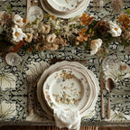 William Morris Pimpernel tablecloth in Sage and Cream on Ebony draped over a table edge
