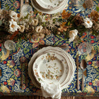 William Morris Strawberry Thief tablecloth in Country Blue draped over a table edge