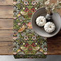 William Morris table runner Strawberry Thief - a floral and bird pattern on a wooden surface with pumpkins and a vase.
