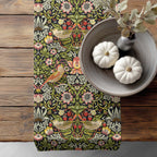 William Morris table runner Strawberry Thief - a floral and bird pattern on a wooden surface with pumpkins and a vase.