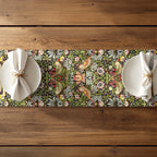 William Morris table runner featuring the Strawberry Thief design with floral and bird pattern on a wooden table.