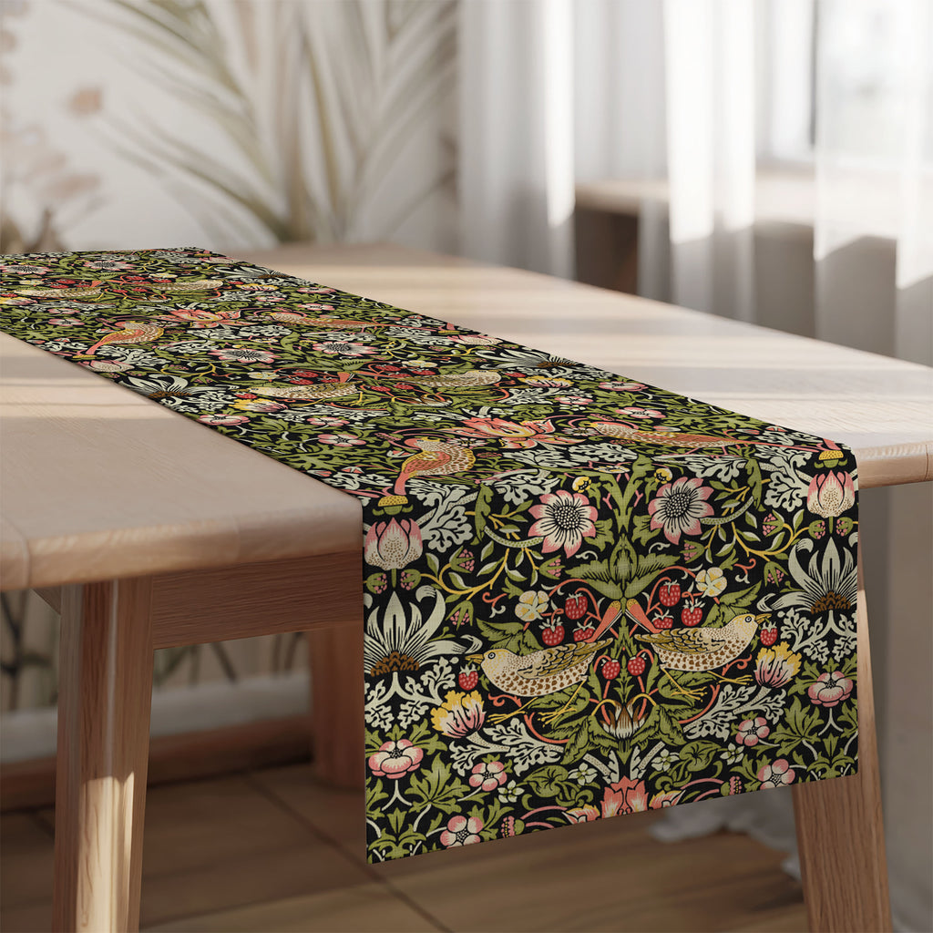 Strawberry Thief William Morris table runner on a wooden table with a blurred indoor background