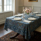 William Morris Blackthorn fabric in Dusky Blue Garden sewn into a tablecloth on a dining table in a panelled English dining room.
