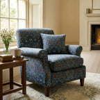 A roll-arm armchair upholstered in William Morris Blackthorn fabric in Dusky Blue Garden.