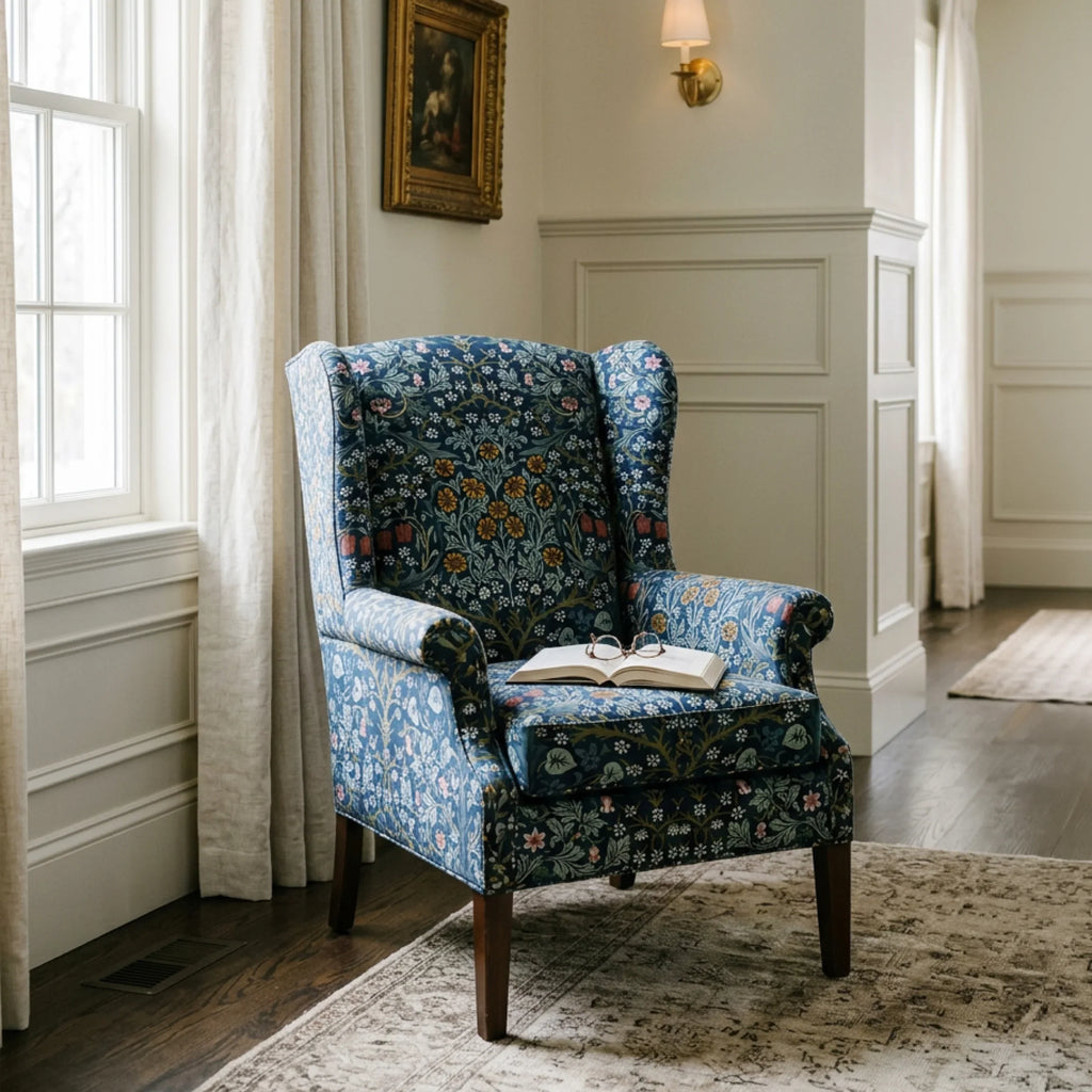 A wingback armchair upholstered in William Morris Blackthorn fabric in Dusky Blue Garden.