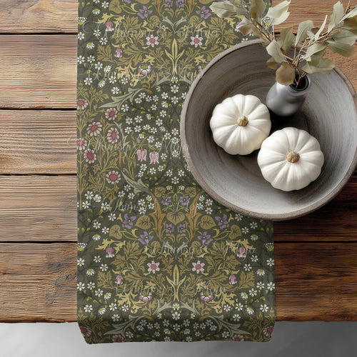 William Morris Blackthorn table runner in Sultry Olive green, with floral pattern on a wooden surface with pumpkins and a vase.