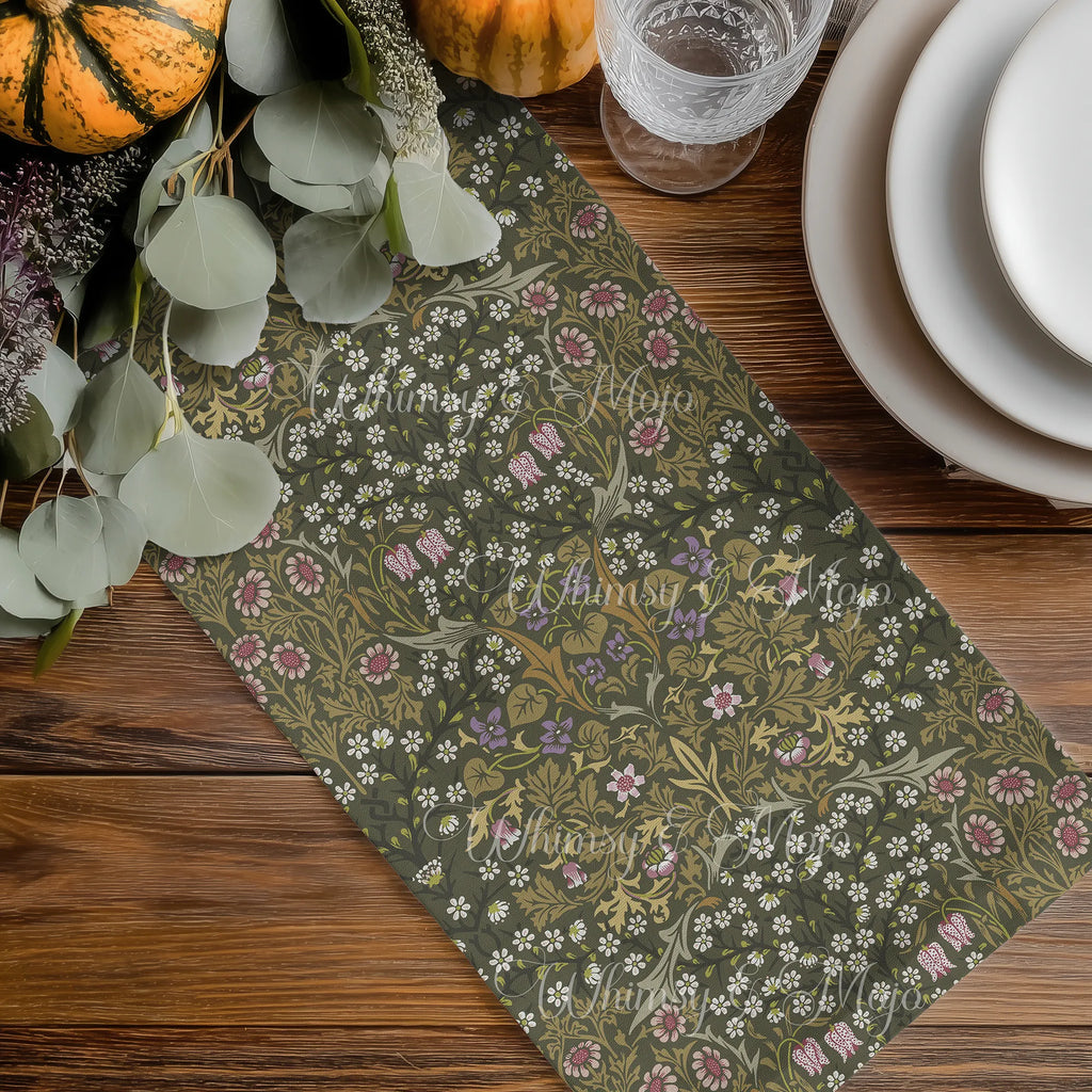 William Morris olive green table runner with floral pattern on a wooden table with pumpkins and glasses.