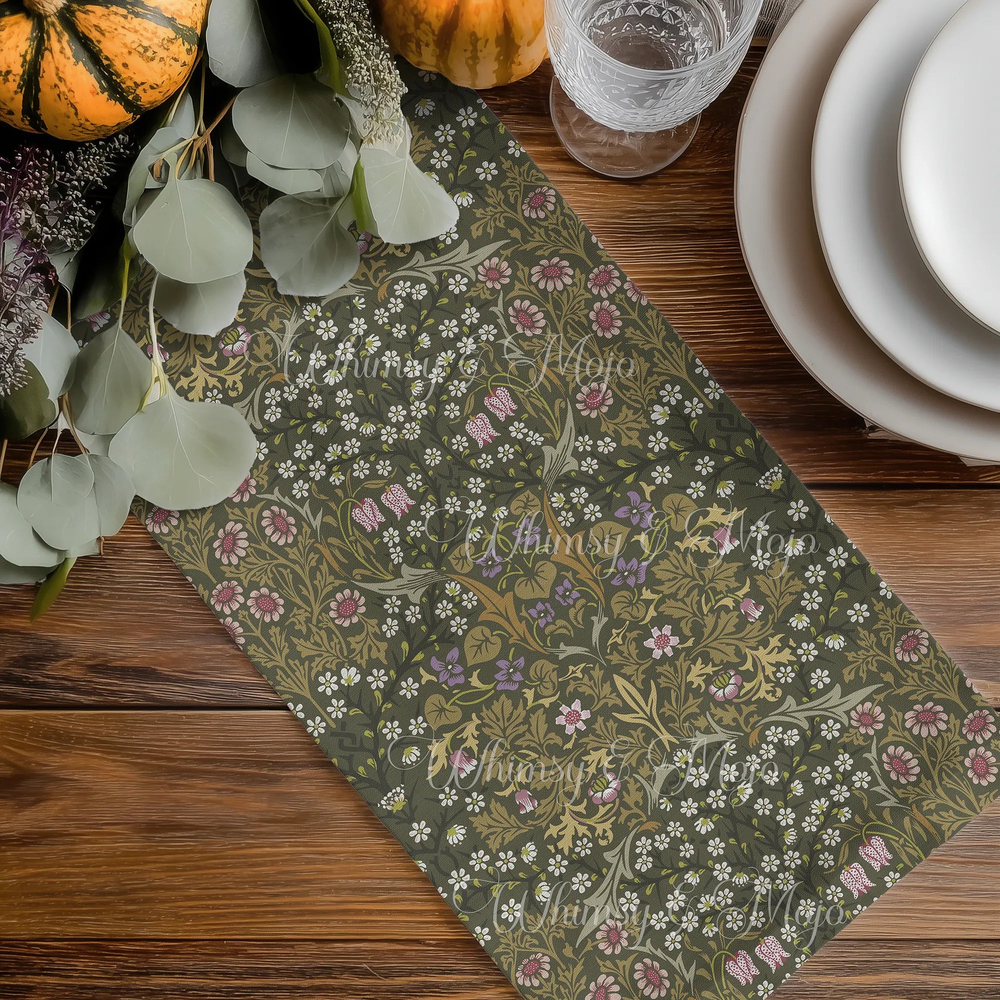 William Morris olive green table runner with floral pattern on a wooden table with pumpkins and glasses.