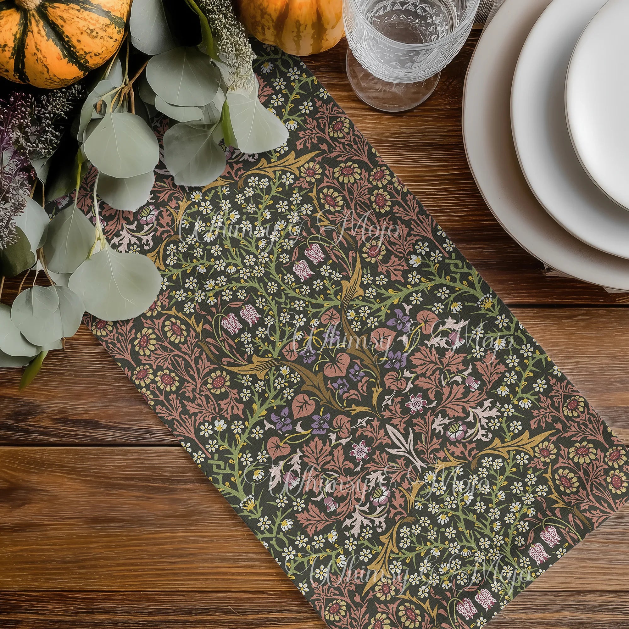 William Morris table runner is beautiful Secret Garden colorway, displayed on a wooden table with pumpkins and glasses.