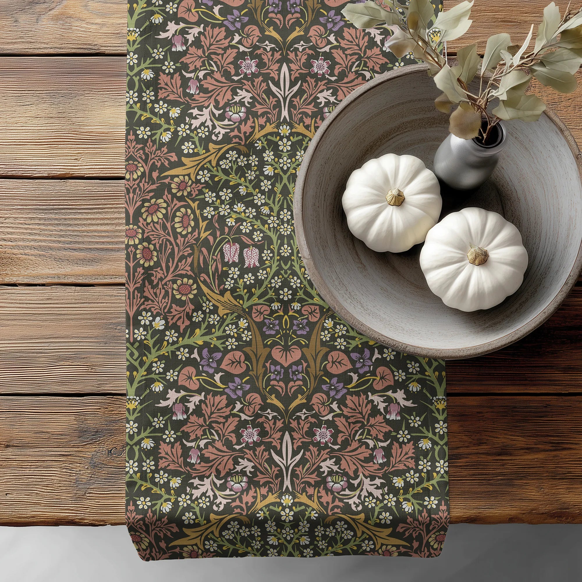 William Morris Blackthorn table runner in Earthy Garden, with floral pattern, on a wooden surface with pumpkins and a vase.