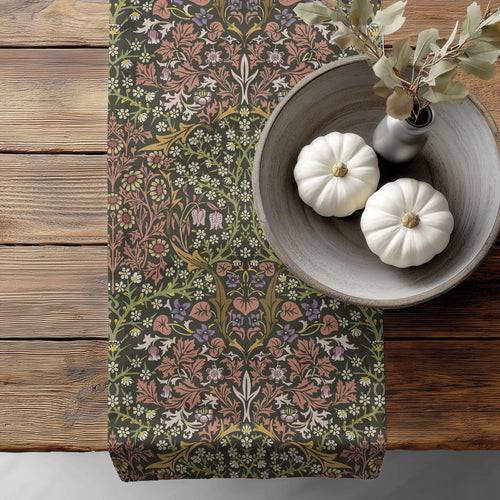 William Morris Blackthorn table runner in Earthy Garden, with floral pattern, on a wooden surface with pumpkins and a vase.
