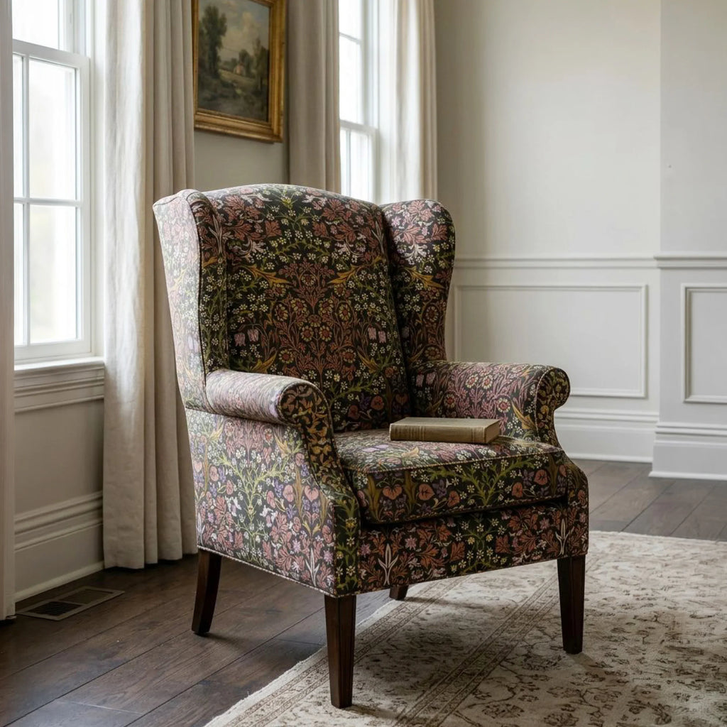 A wingback armchair upholstered in William Morris Blackthorn fabric in Secret Garden.