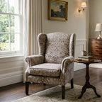 Blackthorn Heritage Taupe upholstery fabric on a wingback armchair in an elegant panelled room