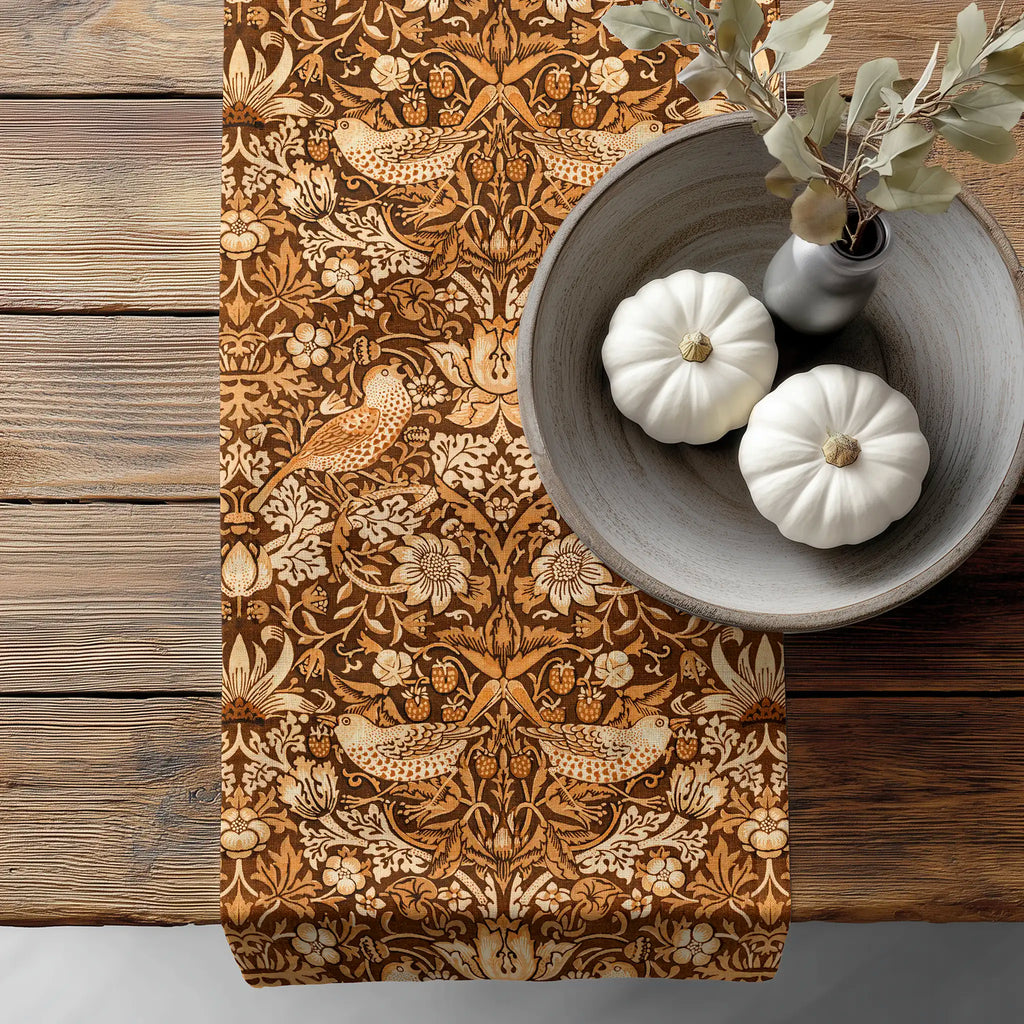 William Morris Strawberry Thief table runner featuring the iconic Arts and Crafts bird and botanical pattern, styled on a rustic wooden table for heritage revival and English country dining decor.