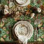 William Morris Strawberry Thief tablecloth in Forest Green draped over a table edge