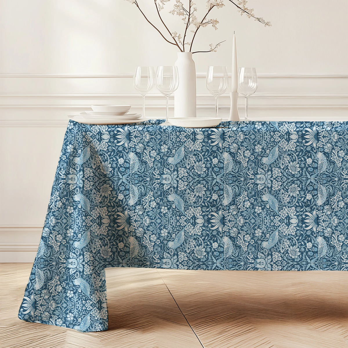 William Morris Strawberry Thief tablecloth in Chambray Blue (4383) draped over a dining table, showing the full drop and corner