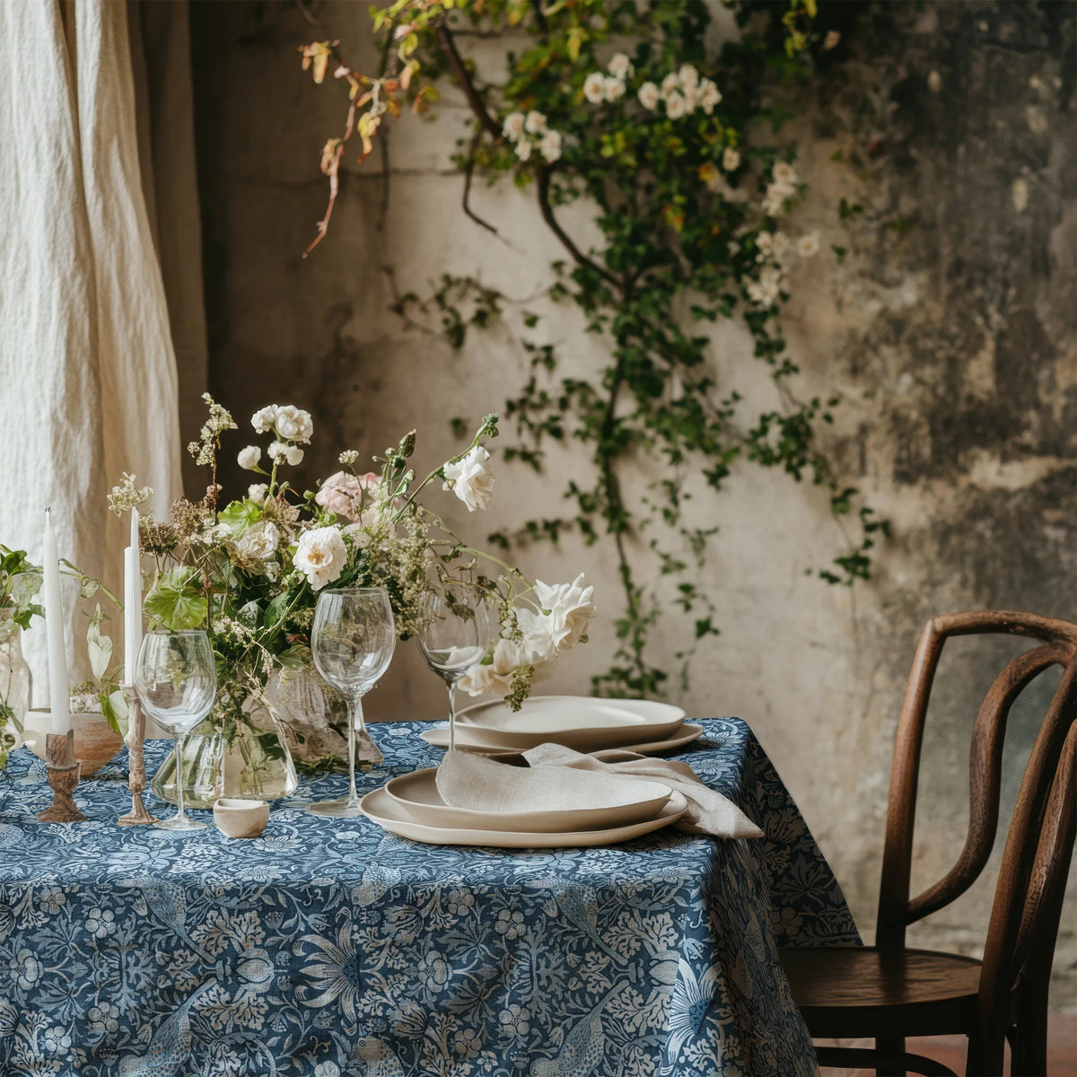 William Morris Strawberry Thief tablecloth in Chambray Blue with a place setting