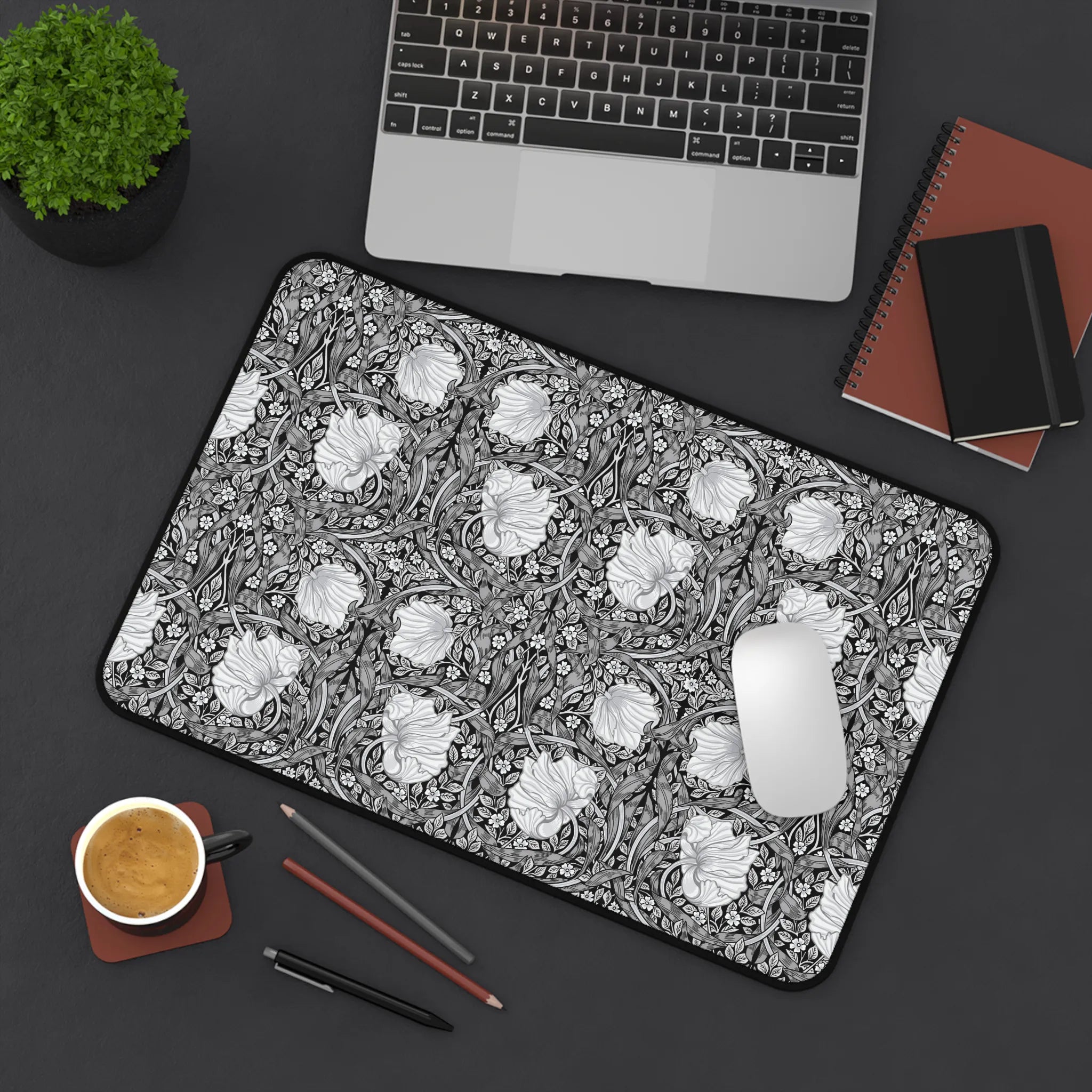 Floral patterned William Morris desk pad on a desk with laptop, notebook, and coffee cup.