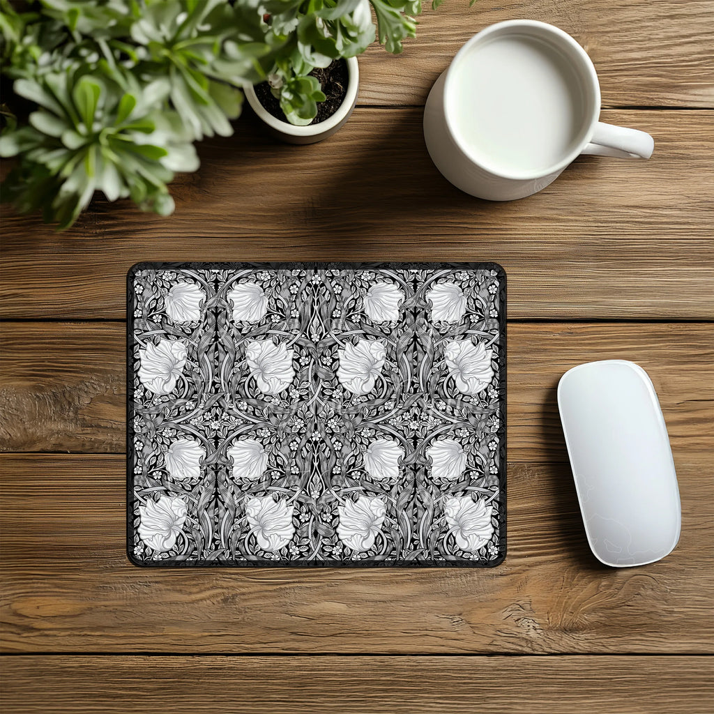 Decorative William Morris mouse pad with floral pattern on a wooden desk with a mug and plant.