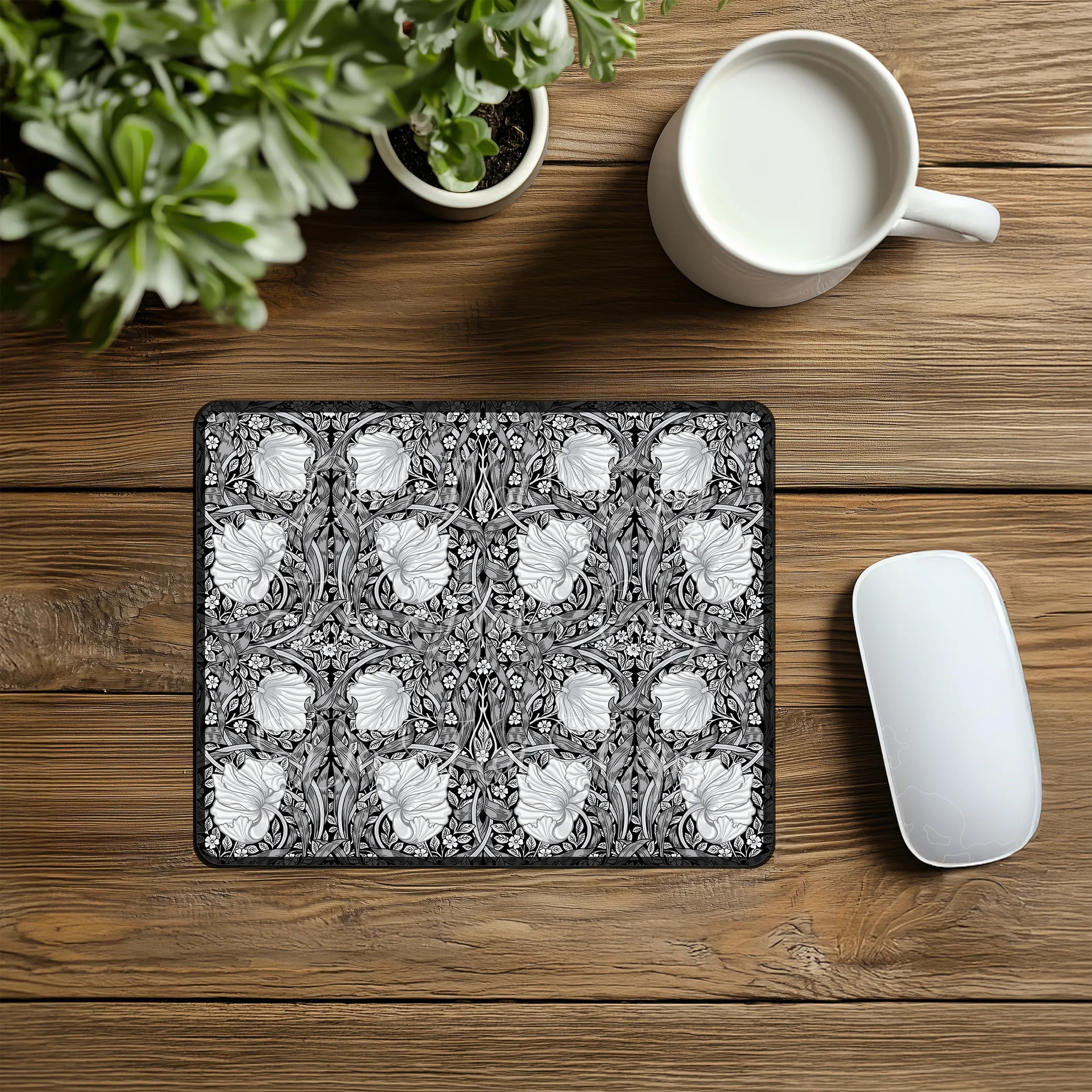 Decorative William Morris mouse pad with floral pattern on a wooden desk with a mug and plant.