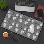 Floral patterned William Morris Pimpernel desk mat on a desk with laptop, coffee, and stationery items.