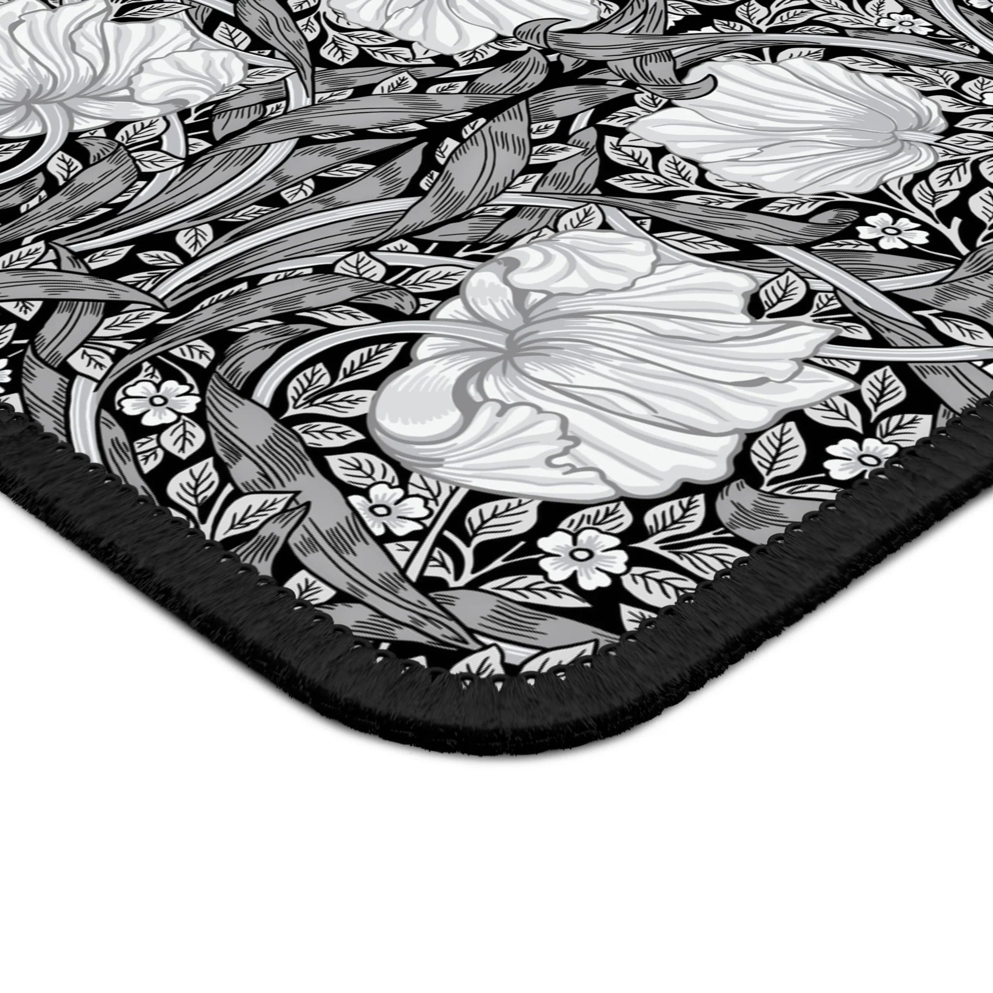Corner close-up of the William Morris Pimpernel desk mat in Black & White, showing the printed surface and stitched edge.