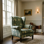 Wingback chair upholstered in William Morris Pimpernel Heritage Green beside a mahogany side table