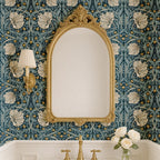 William Morris Pimpernel wallpaper shown in bathroom with ornate mirror and gold fixtures.