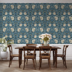 Dining room with William Morris wallpaper, wooden table and chairs. Pimpernel floral wallpapered wall.