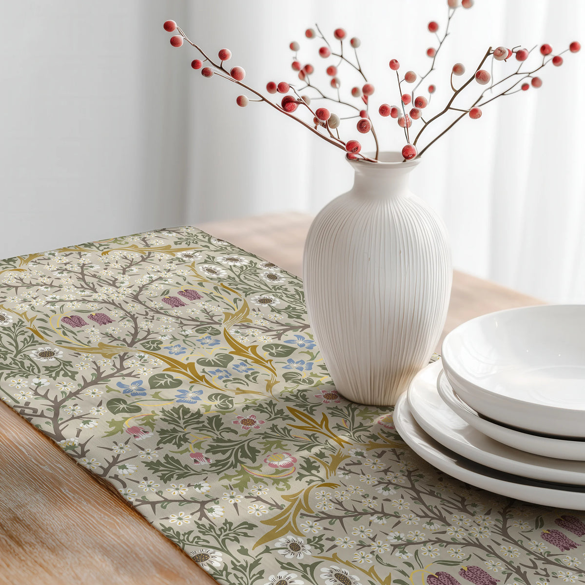 William Morris Blackthorn table runner in Parchment & Moss with a white vase of red berries and stacked white plates