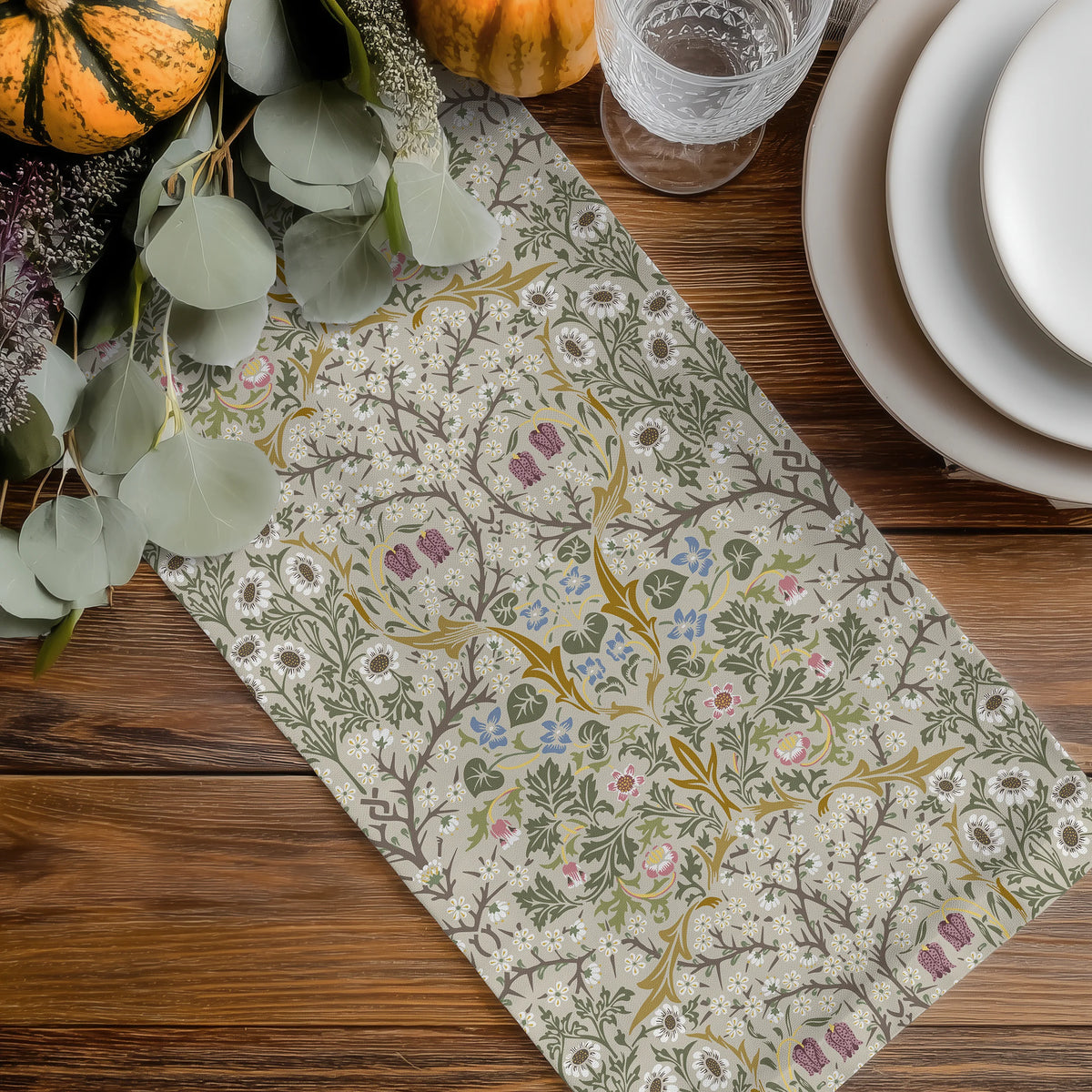 William Morris Blackthorn table runner in Parchment & Moss on a wood table with eucalyptus, pumpkins and white plates