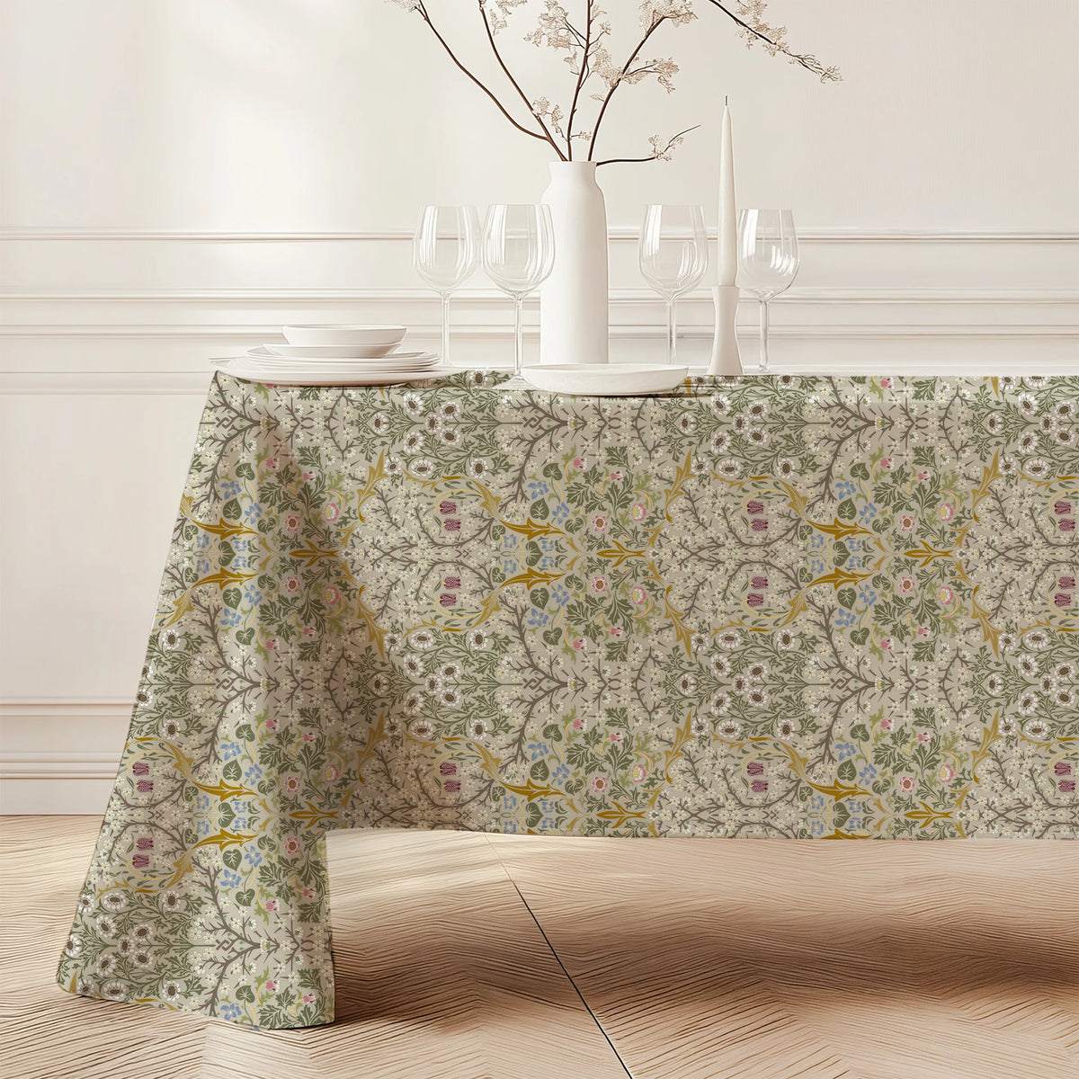 William Morris Blackthorn tablecloth in Parchment & Moss falling to the floor on a dining table with a white vase and candles