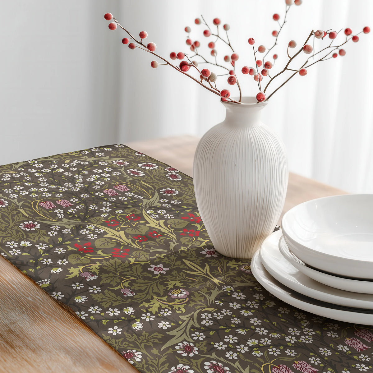 William Morris Blackthorn table runner in Chocolate & Olive with a white vase of red berries and stacked white plates