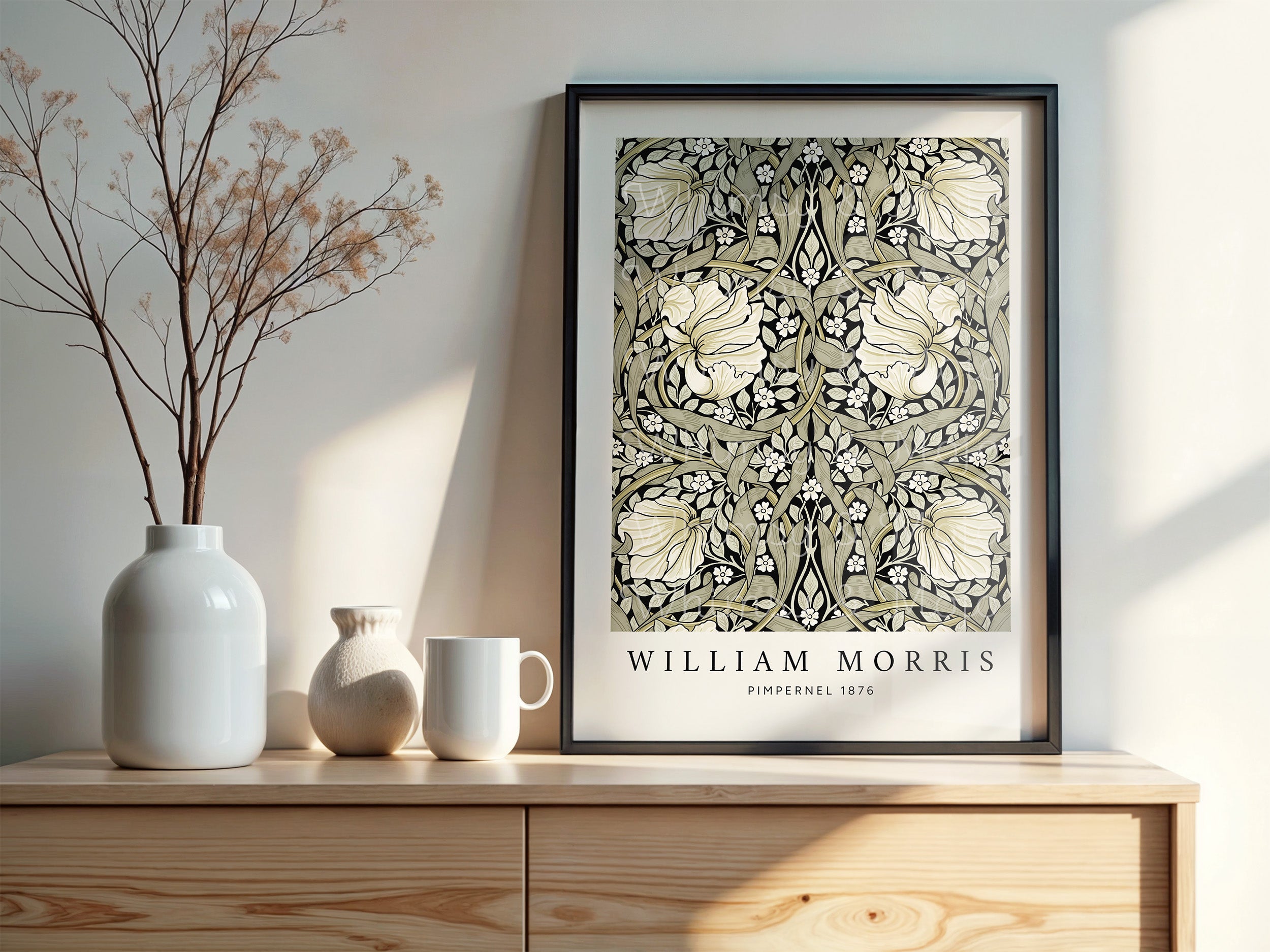 William Morris Pimpernel poster in sage and black, shown framed in a black frame and displayed on top of a cabinet