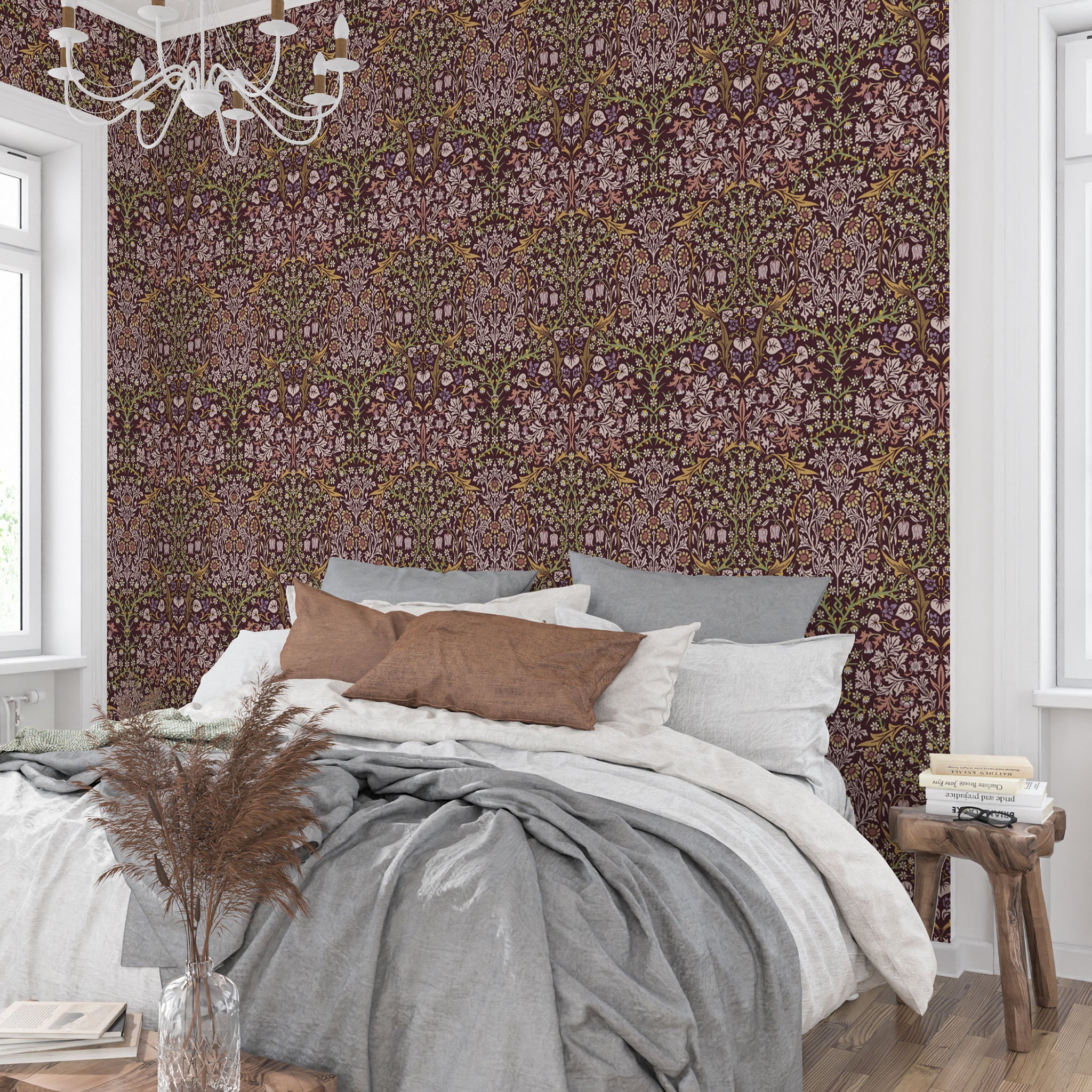 William Morris Blackthorn wallpaper in maroon featured behind a bed in a cozy bedroom, creating a warm heritage revival atmosphere with intricate floral pattern.