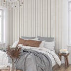 Neutral stripe wallpaper in linen and tobacco tones behind a bed, creating a calm French country bedroom with cottagecore and heritage-inspired decor.