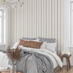 Neutral stripe wallpaper in linen and tobacco tones behind a bed, creating a calm French country bedroom with cottagecore and heritage-inspired decor.