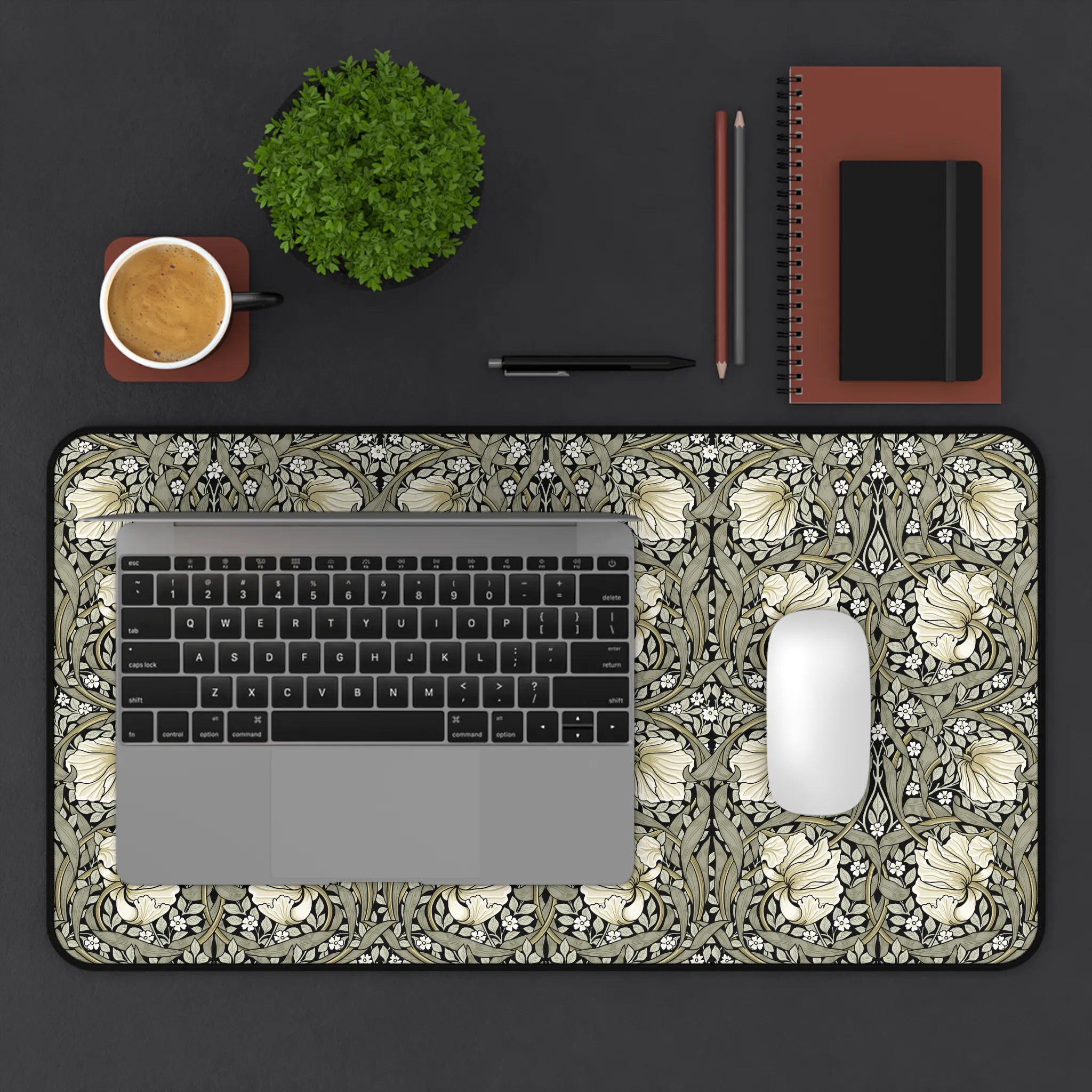 William Morris desk mat with a laptop, mouse, and office supplies on a dark surface