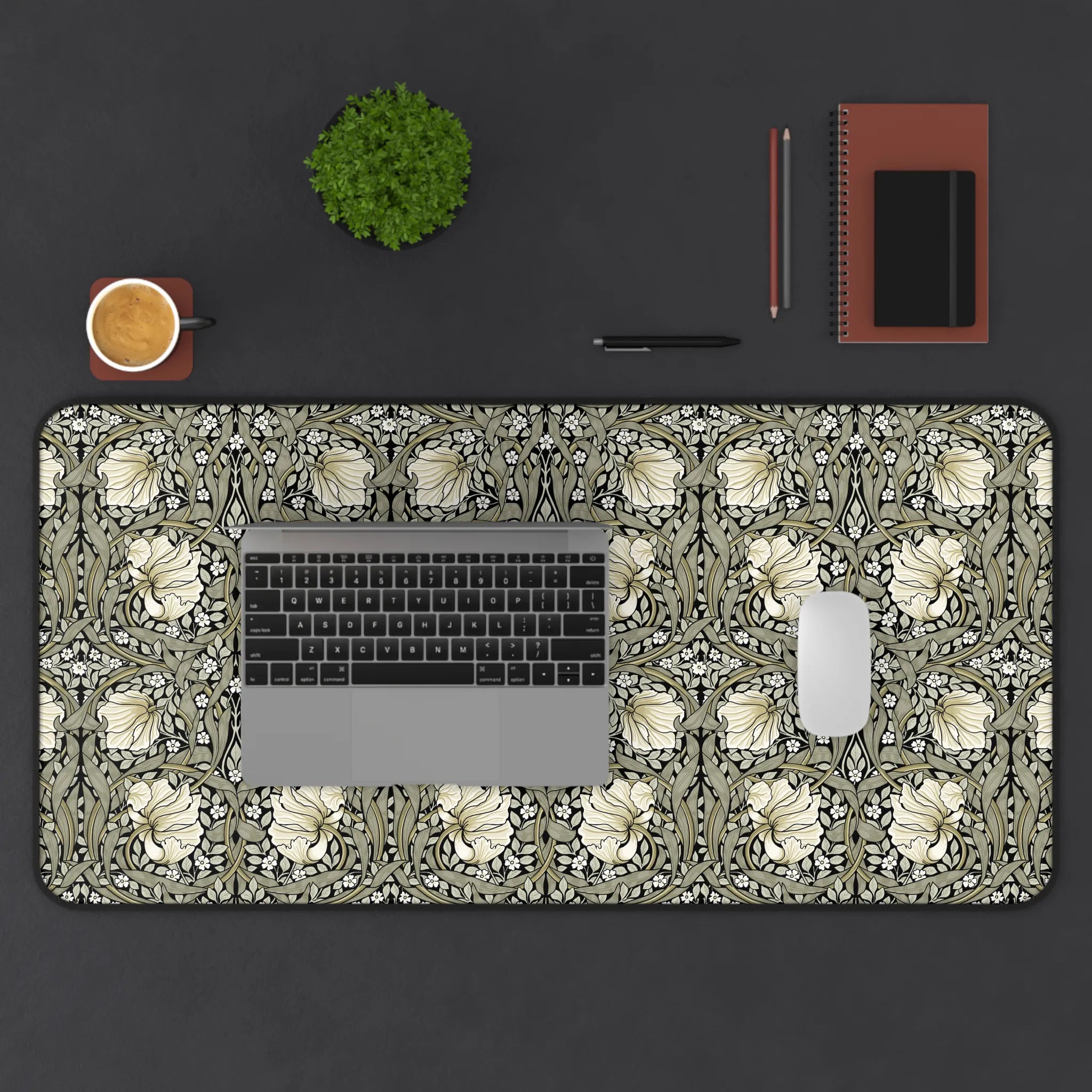 William Morris desk mat with a laptop, mouse, and office supplies on a dark surface.