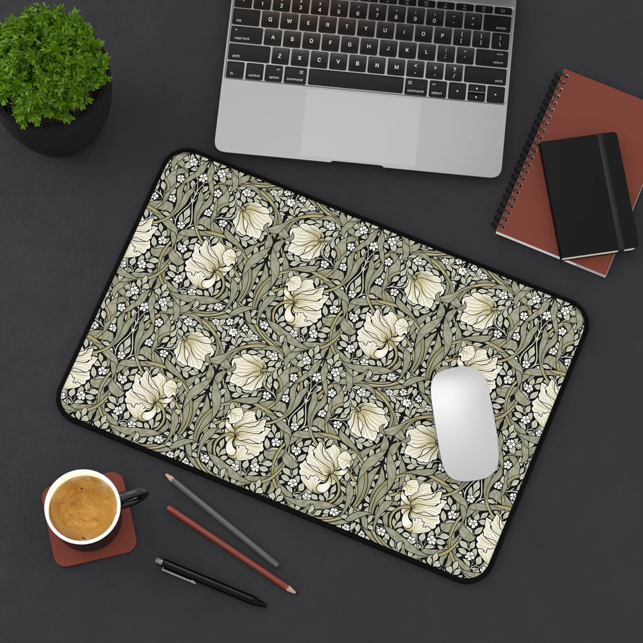 William Morris desk mat on a desk with laptop, notebook, and coffee cup.