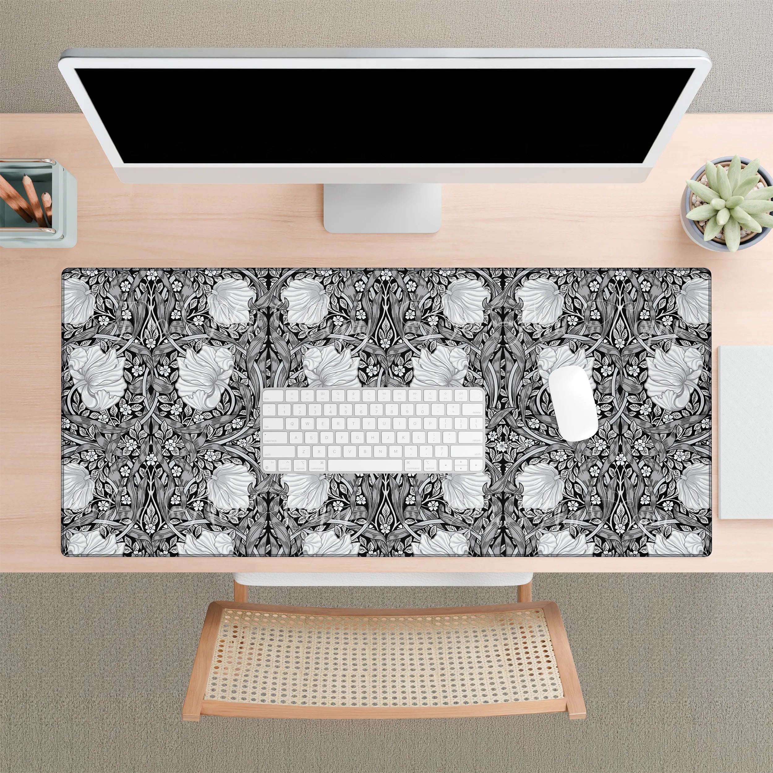 Desk setup with a William Morris desk mat in black and white, keyboard, and computer monitor.