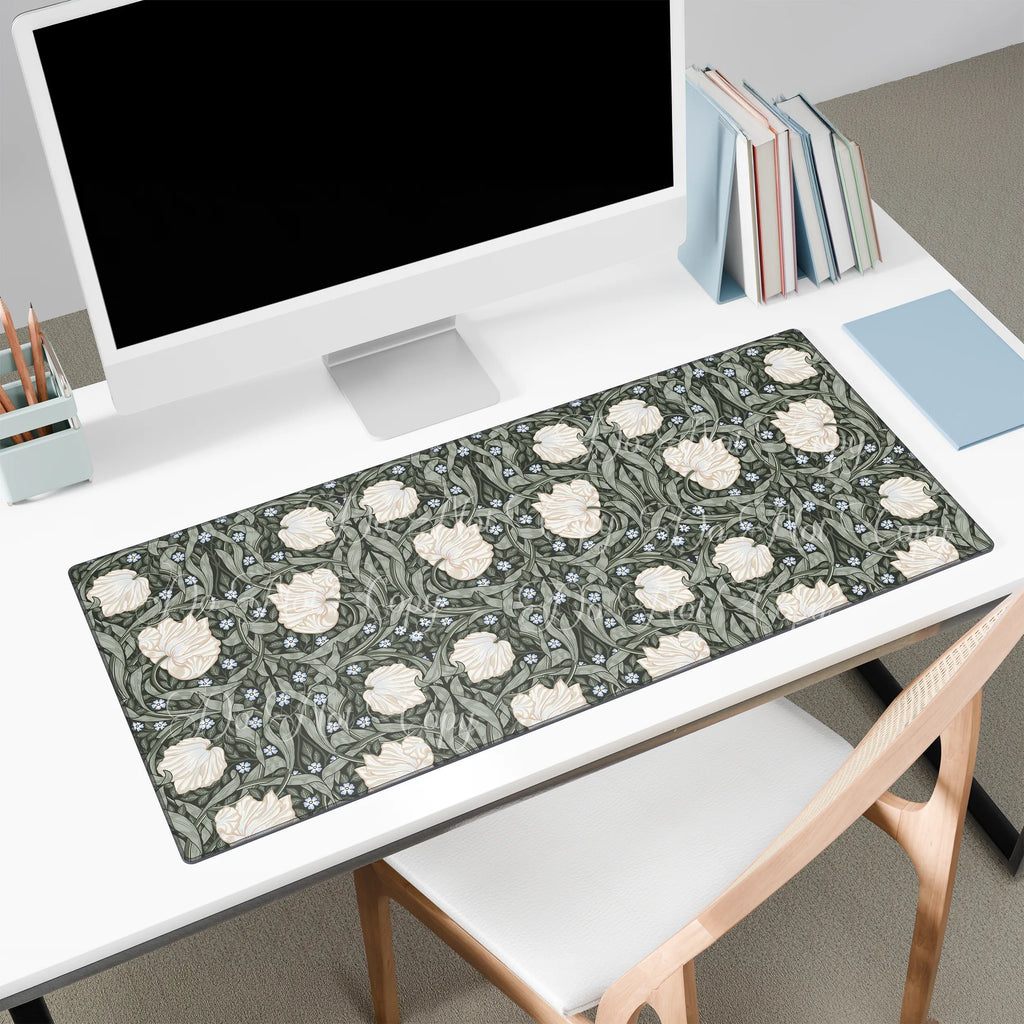 Large floral William Morris desk mat on a white desk with a computer monitor and books.
