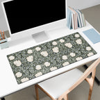 Large floral William Morris desk mat on a white desk with a computer monitor and books.