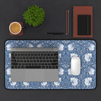 Laptop on a floral William Morris Pimpernel desk mat with a cup, plant, pen, and notebook on a dark surface