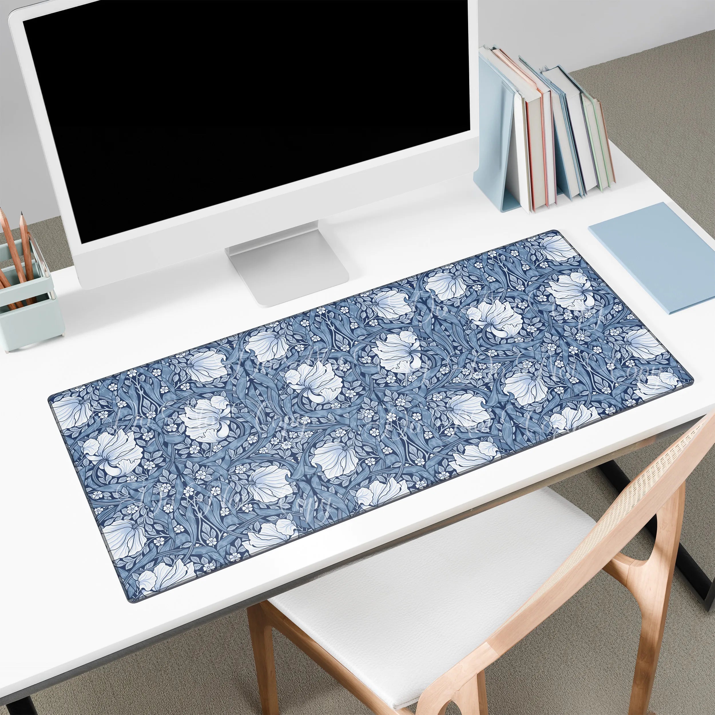Floral patterned blue Pimpernel William Morris desk mat on a white desk with a computer setup