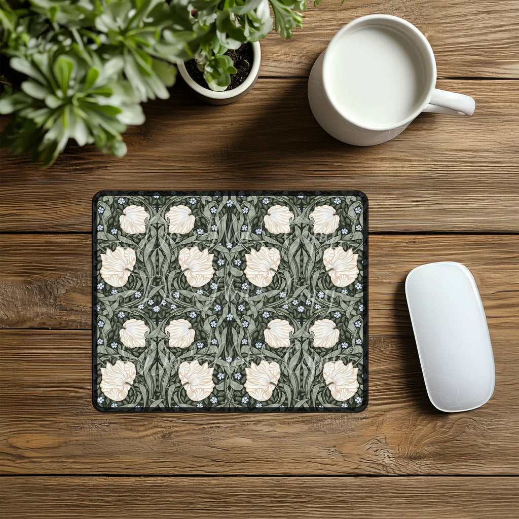 Decorative William Morris Pimpernel mouse pad with floral pattern in sage green and cream, on a wooden desk with a mug and plant.
